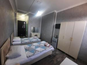 a small room with two beds and a cabinet at Butik in Ganja