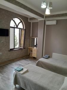 a hotel room with two beds and a window at Butik in Ganja