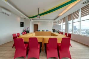 a conference room with a large table and red chairs at Life The One Makassar in Makassar
