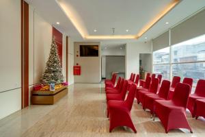 a conference room with red chairs and a christmas tree at Life The One Makassar in Makassar