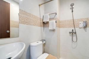 a bathroom with a toilet and a sink and a shower at Life The One Makassar in Makassar