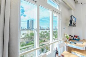 een kamer met een groot raam met uitzicht op de stad bij Palmier Hotel - Art House Da Nang in Da Nang