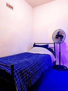 een slaapkamer met een bed en een ventilator bij Griya Backpacker Pak yon in Malang