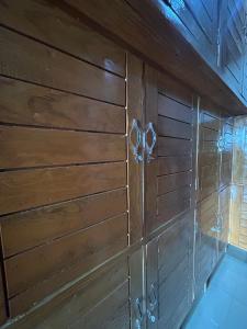a wooden wall with a pair of scissors on it at Dadhwal Zostel in Dharmsāla