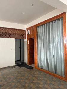 an empty room with a sliding glass door at Dadhwal Zostel in Dharmsāla
