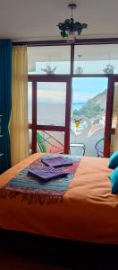 een slaapkamer met een bed en een groot raam bij Jardín Andino Hostal in Copacabana