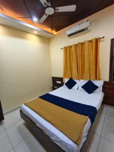 ein Schlafzimmer mit einem großen Bett und blauen Kissen in der Unterkunft Galaxy Beach Residency in Velankanni