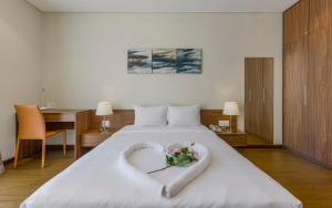 a bedroom with a large bed with a heart shaped bedspread at Aurora Serviced Apartments in Ho Chi Minh City