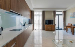 a kitchen with a counter and a living room at Aurora Serviced Apartments in Ho Chi Minh City