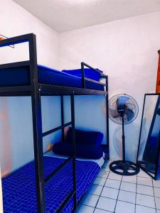 een kamer met 2 stapelbedden en een ventilator bij Griya Backpacker Pak yon in Malang