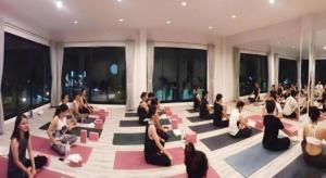 een groep mensen die in een kamer yoga doen bij Fun Hotel in Ban Thai Wat Khot