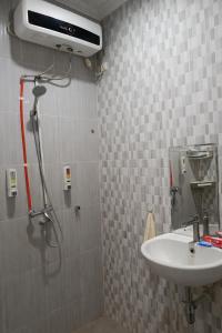 een badkamer met een douche en een wastafel bij ABC Homestay in Sentool