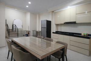 een keuken met een tafel, stoelen en een koelkast bij ABC Homestay in Sentool