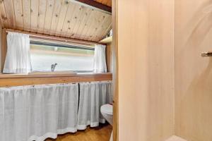 a bathroom with a toilet and a sink and a window at 0009-Romo-Thadesvej-37 in Høm +13 photos