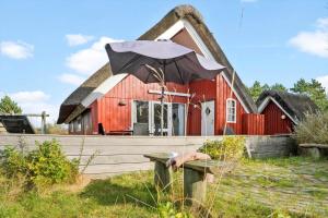 a red barn with an umbrella in front of it at 0009-Romo-Thadesvej-37 in Høm