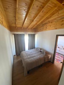 een groot bed in een kamer met een houten plafond bij playanorte in Choapa