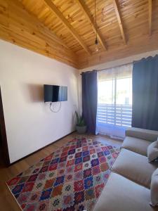 een woonkamer met een bank en een tapijt bij playanorte in Choapa +18 foto's