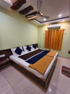 ein Schlafzimmer mit einem großen Bett und blauen Kissen in der Unterkunft Galaxy Beach Residency in Velankanni + 5 Fotos