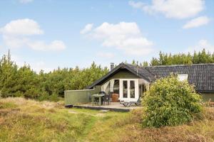 een klein huis met een veranda en een patio bij 2555-Romo-A-M-Listsvej-6 in Tagholm