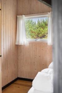 een slaapkamer met een raam en een bed met witte lakens bij 2555-Romo-A-M-Listsvej-6 in Tagholm