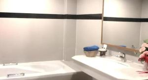 un bagno bianco con lavandino e specchio di PC Palace Hotel a Sakon Nakhon Altre 39 foto