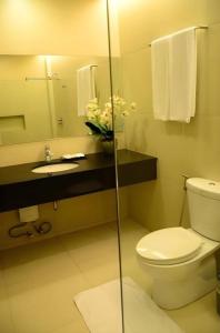 a bathroom with a toilet and a sink and a mirror at GT Hotel Bacolod in Bacolod