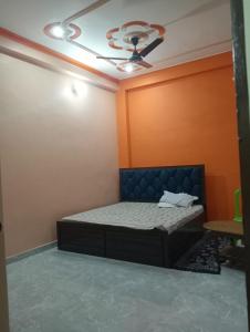 a bedroom with a bed and a ceiling fan at Om Mansion in Varanasi