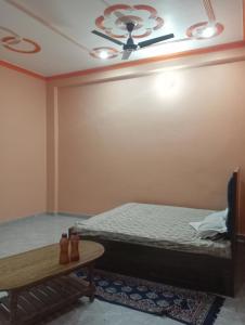 a bedroom with a bed and a ceiling fan at Om Mansion in Varanasi