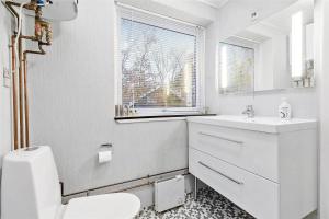 a white bathroom with a toilet and a sink at 11804-Nykobing-Sj-Linesvej-2 in Nyrup +16 photos