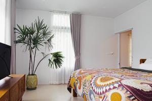 ein Schlafzimmer mit einem Bett und einer Topfpflanze in der Unterkunft Villa Verde Ko Phangan in Haad Pleayleam + 37 Fotos