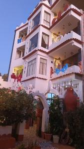 een groot wit gebouw met bomen ervoor bij Jardín Andino Hostal in Copacabana