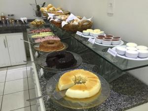 a counter with many different types of cakes and pastries at Smart Hotel in Registro