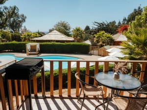 a balcony with a table and chairs and a pool at Pao Pao Lodge Algarrobo in Algarrobo