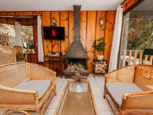 a porch with wicker chairs and a fireplace at Pao Pao Lodge Algarrobo in Algarrobo +29 photos