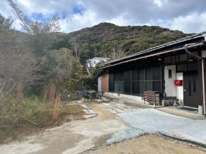 een gebouw met tafels en stoelen naast een berg bij GuestHouse" Ro "Umegato in Kogushi