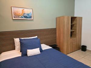 a bedroom with a blue bed and a wooden cabinet at Confort en La Unión in La Unión