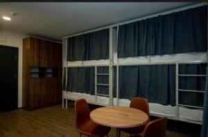 Cette chambre dispose d'une table, de chaises et de grandes fenêtres. dans l'établissement Gоderdzi Twins Hotel, à Goderdzi