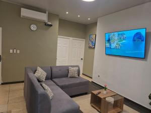 a living room with a couch and a tv on a wall at Confort en La Unión in La Unión
