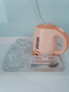 een theepot en een glazen pot op een plank bij Daily Relax Inn -Apartment Rooms- Hulhumale' in Furanafushi