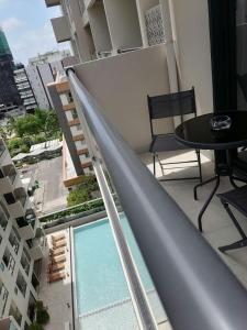 een balkon met een tafel en een zwembad bij Daily Relax Inn -Apartment Rooms- Hulhumale' in Furanafushi