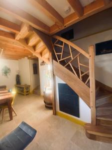 een woonkamer met een houten trap in een huis bij La Longère des Oies in La Celle-sous-Gouzon