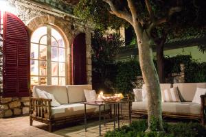 eine Terrasse mit 2 Sofas und einem Tisch mit Kerzen in der Unterkunft Casa Oasi in Taormina