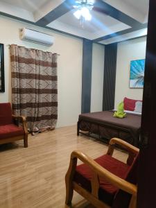 ein Zimmer mit einem Bett und einem Stuhl darin in der Unterkunft St. John Island View Pensionne in El Nido