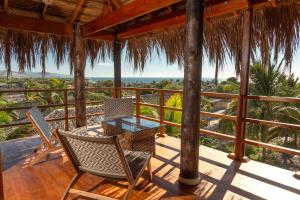 a patio with a table and chairs on a deck at Olas y Arena in Vichayito