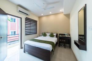 um quarto com uma cama grande e uma janela em Treebo Trend Adin Residence Chennai Trade Centre em Chennai