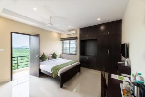 a bedroom with a bed and a large window at Treebo Trend Adin Residence Chennai Trade Centre in Chennai