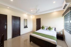 Un dormitorio con una cama grande y una ventana en Treebo Trend Adin Residence Chennai Trade Centre en Chennai