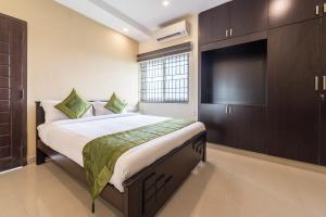 um quarto com uma cama grande e uma televisão de ecrã plano em Treebo Trend Adin Residence Chennai Trade Centre em Chennai