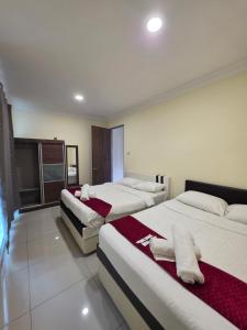 a hotel room with three beds in a room at Teeview Homes 9A in Tanah Rata