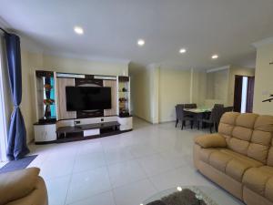 a living room with a couch and a television at Teeview Homes 9A in Tanah Rata